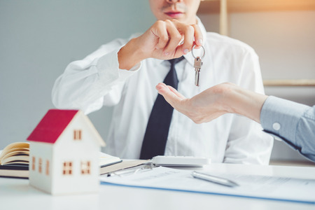 Sale agent giving Key house to customer and sign agreement contract, Insurance Home conceptの写真素材