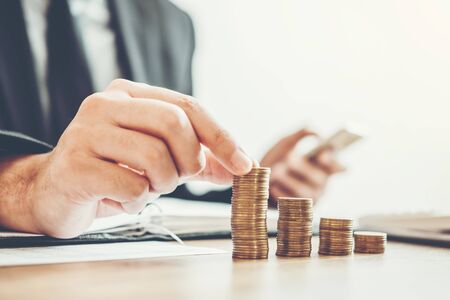 Business man Accounting Calculating Cost Economic budget putting Row and coin Write Finance ,investment and saving conceptの写真素材