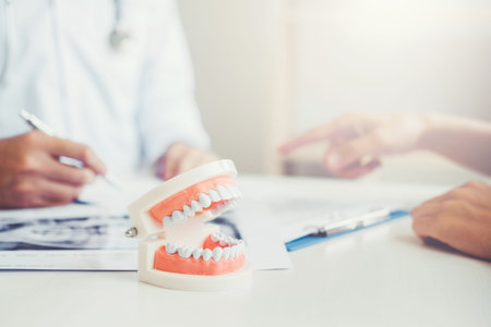 Dentist talking to male patient and presenting results on Dental x-ray film About the problem of the...