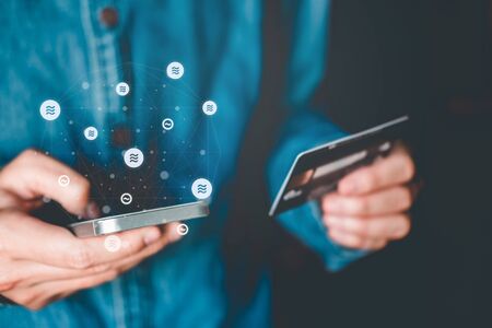 Libra Cryptocurrency Online banking businessman using smartphone with credit card Fintech and Blockchain conceptの写真素材