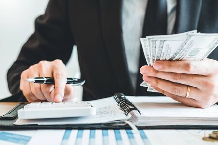 Business man Accounting Calculating Cost Economic budget putting Row and coin Write Finance ,investment and saving conceptの写真素材