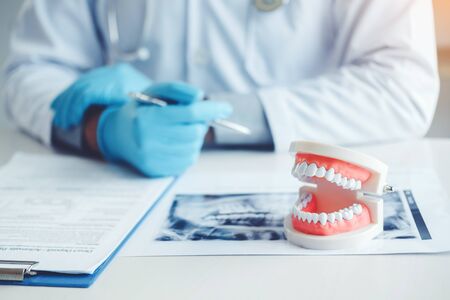 Dentist consulting with patient presenting results on Dental x-ray film About the problem of the patientの写真素材