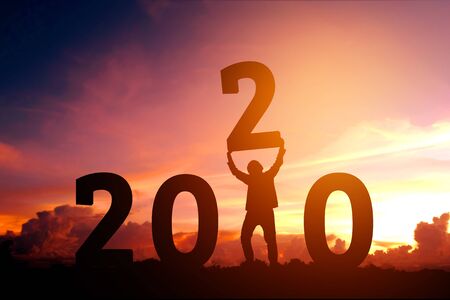 2020 Newyear Man tries to Lift up number of 2020 Happy new year conceptの写真素材