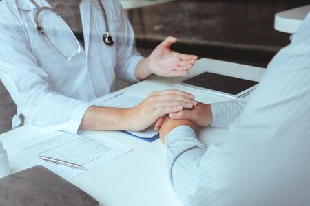Doctor holding hands for comforting and care patient hospital and medicine conceptの写真素材