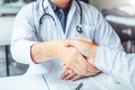 Confident Doctor shaking hands with patients talk in the hospitalの写真素材