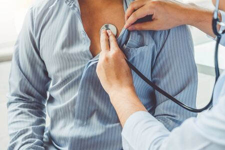 Doctor Measuring arterial blood pressure man patient Health care in hospitalの写真素材
