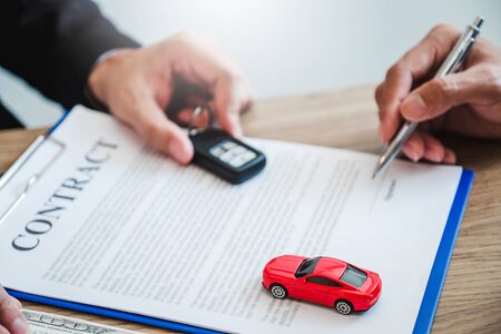 Sale agent  deal to agreement successful car loan contract with customer and sign agreement contract  Insurance car concept.の写真素材