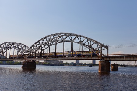 Riga, Latvia - May 25, 2014  Electric train passing railway bridge over Daugava River in Riga, Latviaのeditorial素材