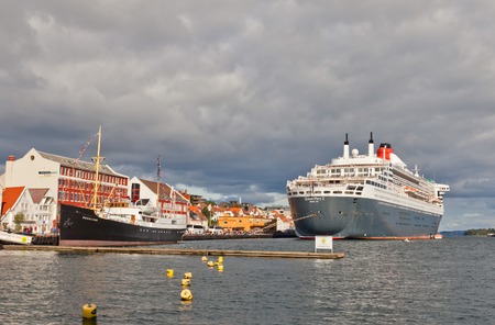 STAVANGER, NORWAY - AUGUST 16, 2014  Cruise ship Queen Mary 2 and museum vessel Rogaland in the port of Stavanger, Norwayのeditorial素材