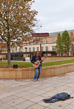 WARSAW, POLAND - OCTOBER 18, 2014: Street musician play guitar on Krakowskie Przedmiescie street (Herbert Hoover Square) in Warsaw, Polandのeditorial素材