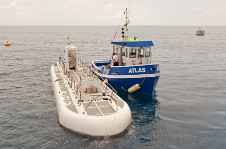 GEORGE TOWN, CAYMAN ISLANDS - SEPTEMBER 24, 2015: Atlantis Submarine and Atlas tugboat near George Town of Grand Cayman. Antlantis is specially designed for tourist underwater toursのeditorial素材