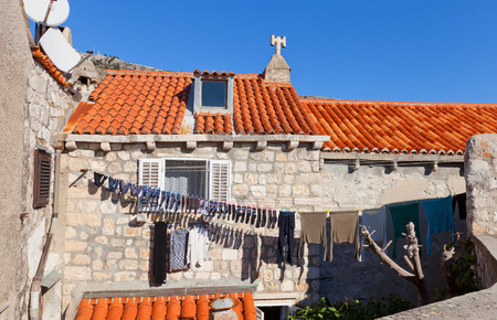 DUBROVNIK, CROATIA - JANUARY 20, 2016: Laundry is drying on the facade of the house adjoined to city ramparts of Dubrovnik , Croatia. Medieval houses of Dubrovnik are still inhabited by common peopleのeditorial素材
