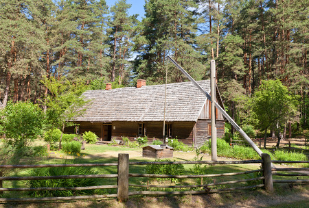 RIGA, LATVIA - JUNE 13, 2016: Dwelling rural house with well (circa 1884) of Delini fishermen farmstead of Kurzeme ethnic group. Exhibited in Ethnographic Open-Air Museum of Latvia since 1971のeditorial素材