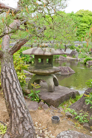 HIMEJI, JAPAN - MAY 16, 2017: Traditional stone lantern (toro) on the pond of Kokoen Garden near Himeji castle, Japan. Garden was laid out in 1992 to commemorate 100 anniversary of Himeji cityのeditorial素材