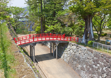 MARIOKA, JAPAN - MAY 22, 2017: Red bridge over the moat between main (honmaru) and second (ninomaru) baileys of former Marioka castle, Japan. Castle was constructed in 1633 and dismantled in 1874のeditorial素材