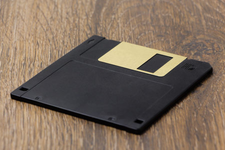 Black diskette (floppy disk) on the table, close-up.