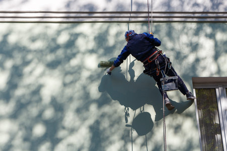 Industrial climber paints a building facade.の写真素材