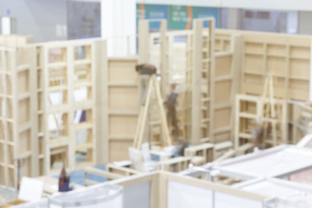Blurred image of the installation of wood and plywood structures for the event.