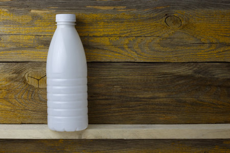 Plastic bottle for dairy products on an aged wooden background.の写真素材