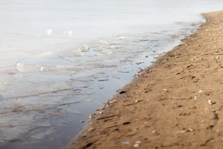 Ice near the sandy shore, spring melting. selective focus.の写真素材