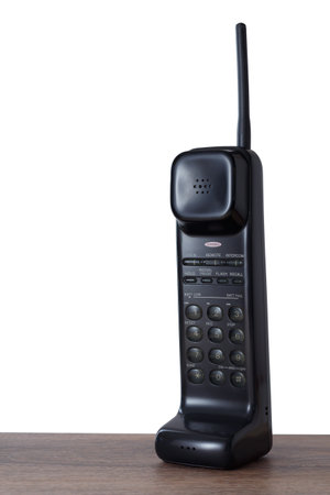 Black retro radio phone with physical keys stands on the table, copy space.の写真素材