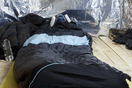 Man is resting a sleeping bag in a respirator in adverse conditions.の写真素材