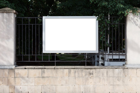 Horizontal rectangular billboard on the fence of the park. Mock up.の写真素材