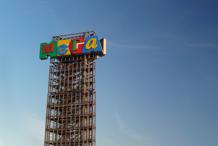 Billboard for a chain store with the words "Mega" on a tall metal truss structure. Moscow, Russia, September 27, 2023のeditorial素材