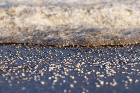 White deicing agent melts ice on the road. Selective focus.の写真素材