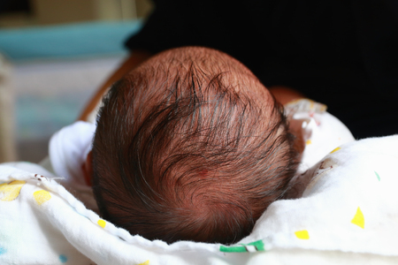 newborn baby head and hair for on white diaper.の写真素材