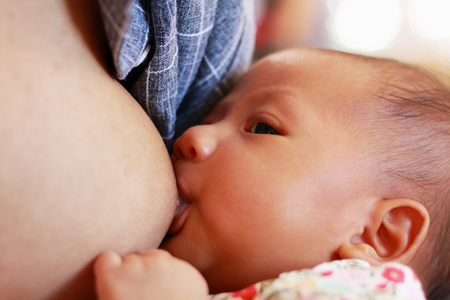 mother is breastfeeding her newborn baby.の写真素材