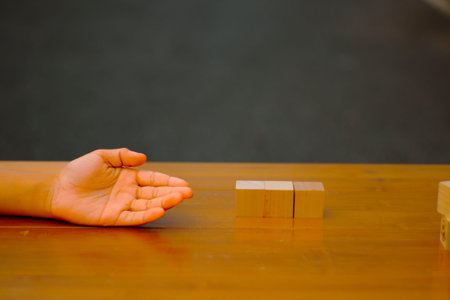 Square wooden blocks and hands, in the idea add words to the wooden blocks. such as the word JOB...