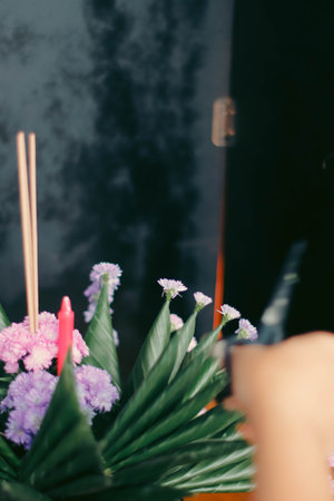 Bouquet of flowers in vase with candle on black backgroundの写真素材
