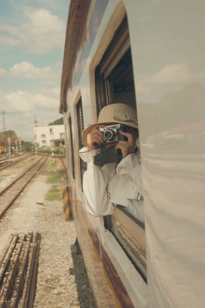Traveler with camera taking photo of train at railway stationの写真素材