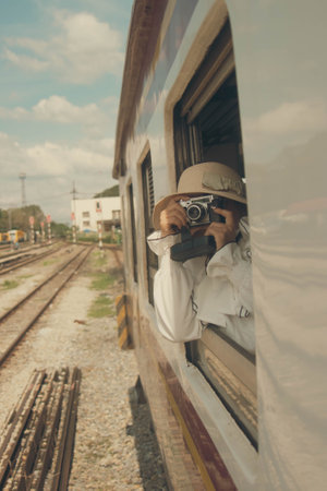 Man taking photo of train in train station, vintage color tone.の写真素材