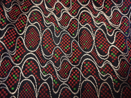 Fabric with a pattern of red, white and green beads.