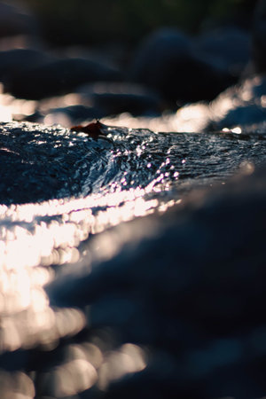 Rocks and water in a stream at sunset, close-up