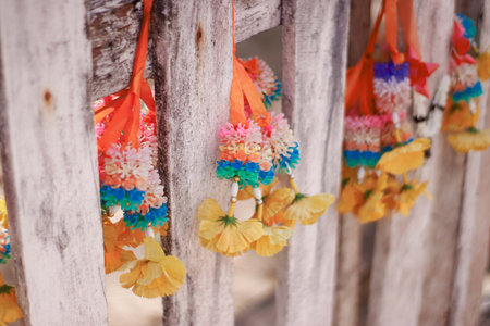 Colorful garland hanging on the wooden fence in Thai temple.
