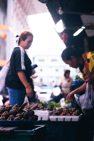 Unidentified Thai people sell fruits at street food market.