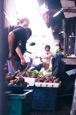 Unidentified Thai people sell fruits and vegetables on the street market.の写真素材