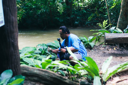 Thai man sitting on the ground and looking at the river.