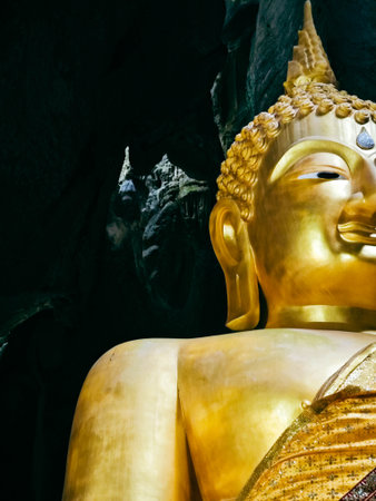 golden buddha statue in cave of thailand, close upの写真素材