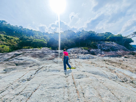 Person standing on the top of the mountain and looking at the skyの写真素材