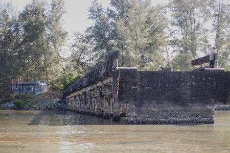 The old concrete bridge on the bank of the river in Thailand.
