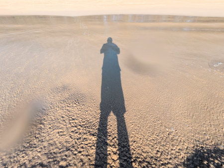Silhouette of a man on the beach at sunset.