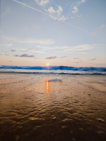 Beautiful sunset on the beach. The sun is reflected in the water.の写真素材