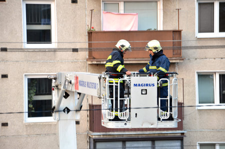 Bytca, Slovakia - June 4, 2016: Two firefighters uprise into telescopic boom basket of fire truck,...