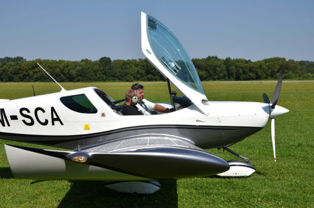 Ocova, Slovakia - August 2, 2014: Two men sit into ultralight propeller-driven airplane and get...