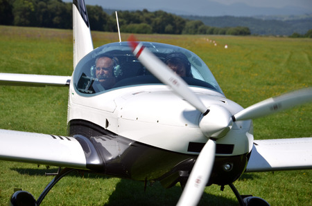 Ocova, Slovakia - August 2, 2014: Two men sit into ultralight propeller-driven airplane and get ready for taking offのeditorial素材