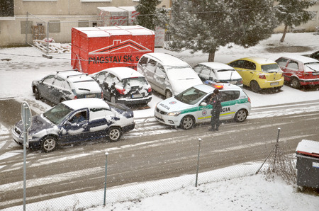 Bytca, Slovakia - February 17, 2017: Police traffic partol stop a car. Policeman stand outside vehicle in bad weather while snow falls.のeditorial素材